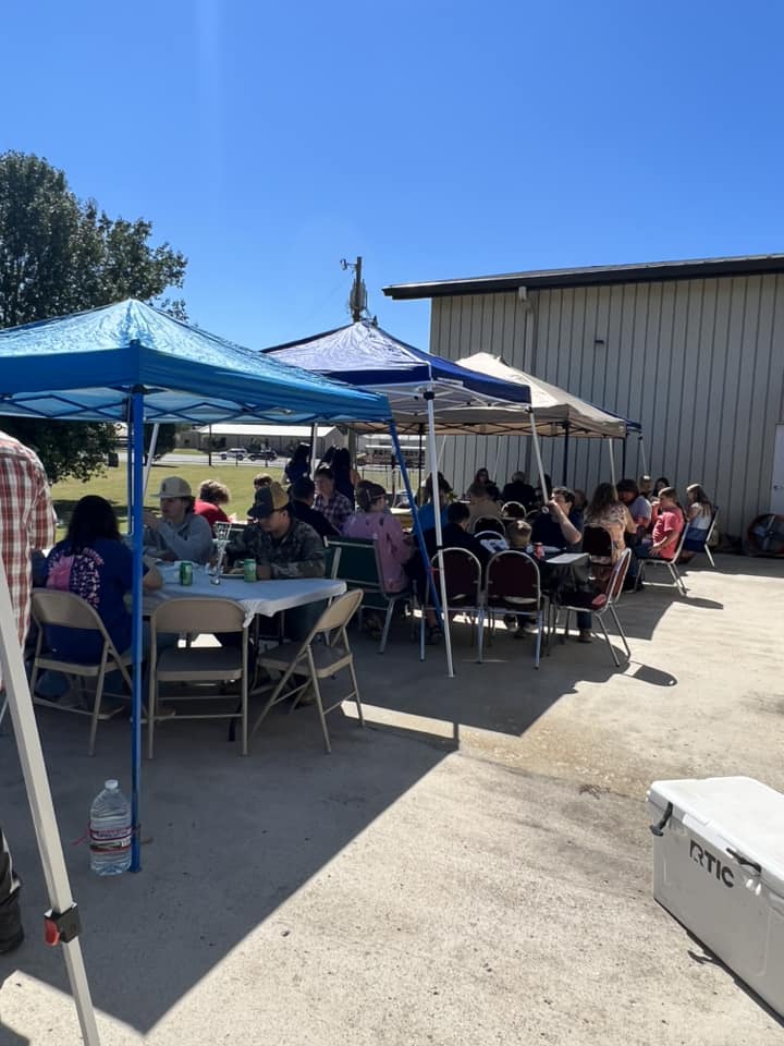 Outdoor church cookout with families under tents